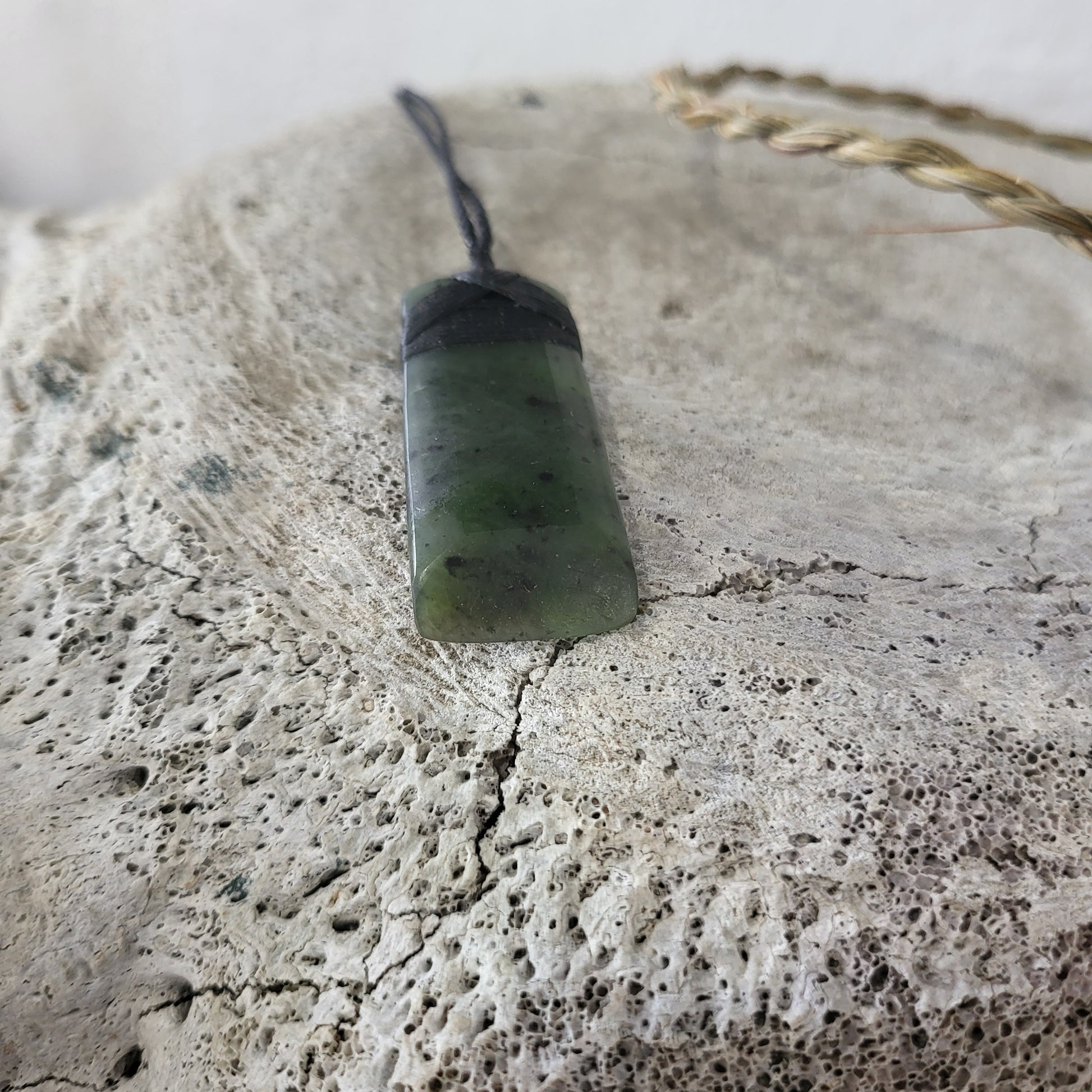 carved pounamu toki (adze) necklace, on black cord
