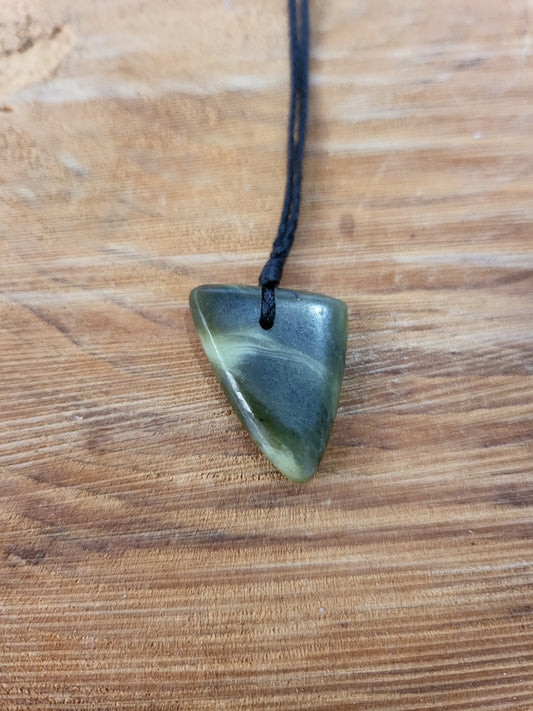 small carved pounamu niho (tooth) necklace on black cord