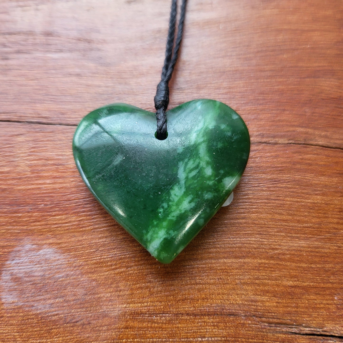 carved pounamu manawa (heart) necklace, beautiful colour variations, on black cord
