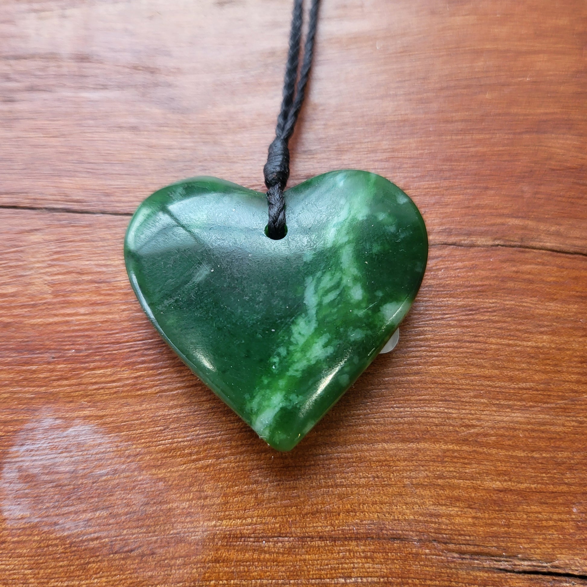 carved pounamu manawa (heart) necklace, beautiful colour variations, on black cord