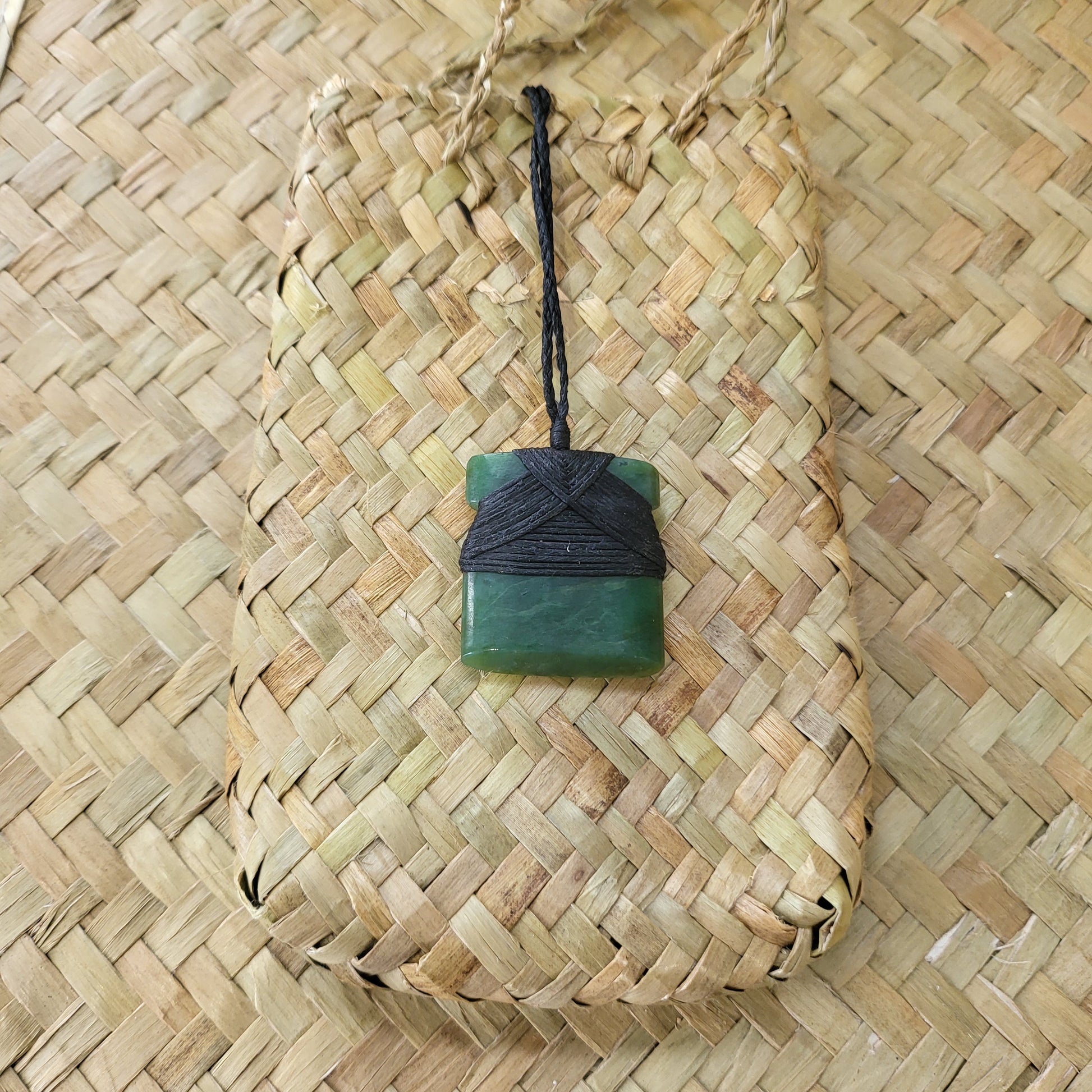small carved pounamu toki (adze) necklace, on black cord