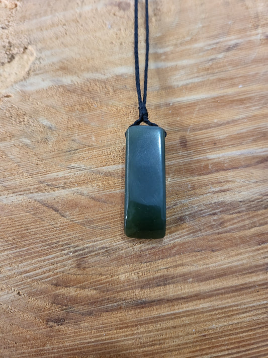 small carved pounamu toki (adze) necklace on black cord