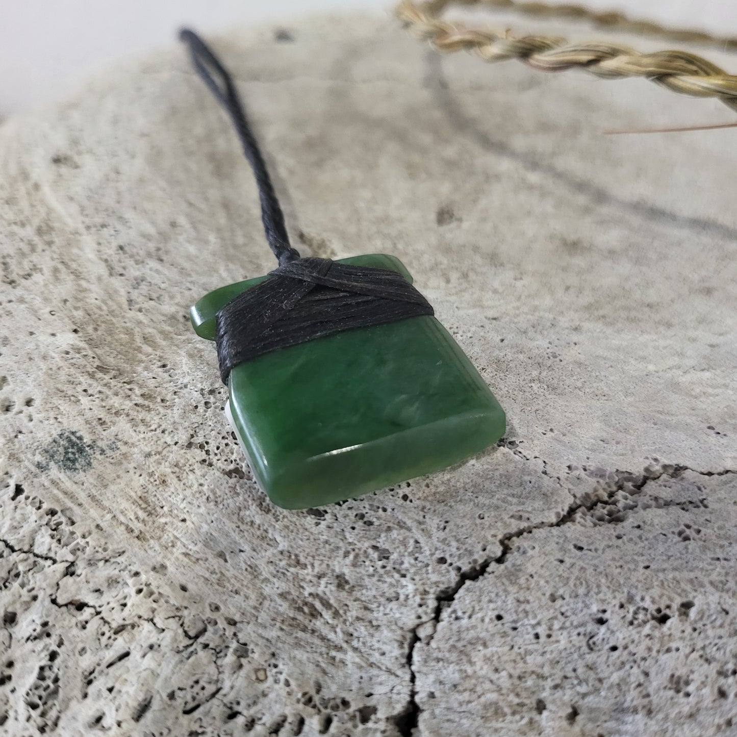 small carved pounamu toki (adze) necklace, on black cord