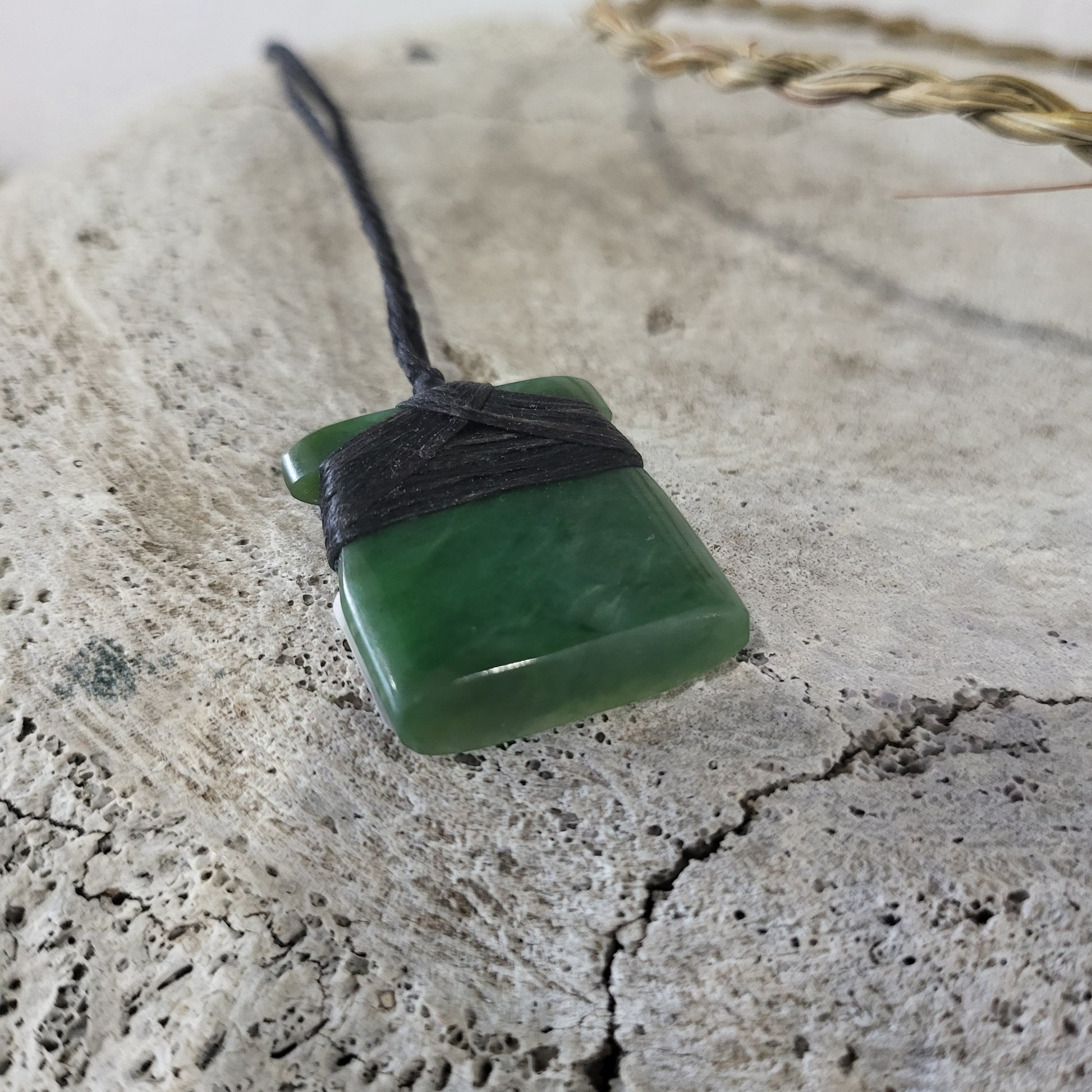 small carved pounamu toki (adze) necklace, on black cord