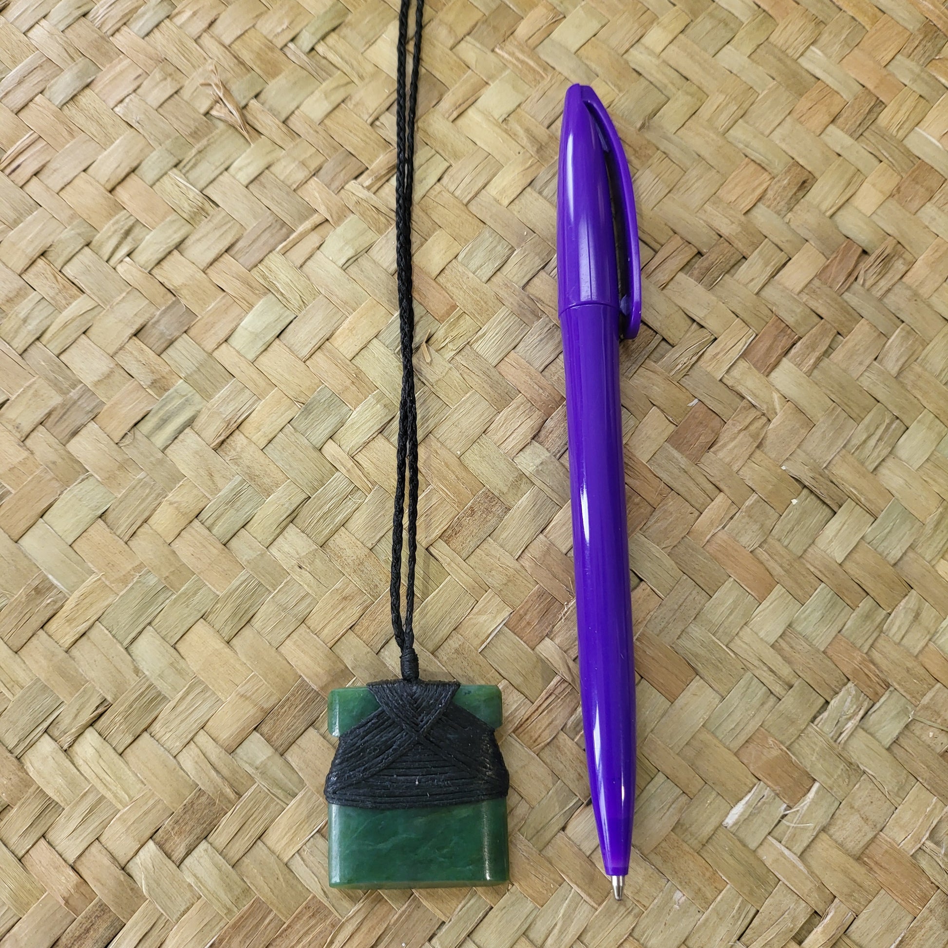 small carved pounamu toki (adze) necklace, on black cord
